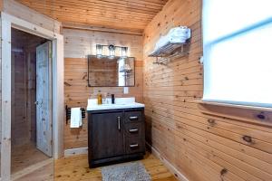 a bathroom with a sink in a wooden wall at Nova Scotia Grover's Cove Seaside Cottages in Larrys River +89 photos