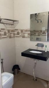 a bathroom with a sink and a mirror and a toilet at Abhi Residency Hotel in New Delhi