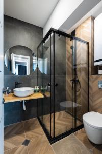 uma casa de banho com uma cabina de duche em vidro e um lavatório. em TOPAZ Beachfront Apartment em Varna City