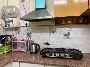a kitchen counter with a stove top in a kitchen at Cozy Room in 3BHK duplex in Dehradun