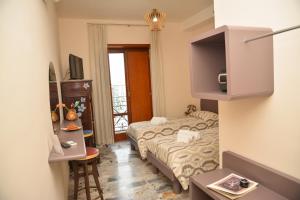ナポリにあるFURTURE'Roomsの小さなベッドルーム(ベッド1台、テレビ付)