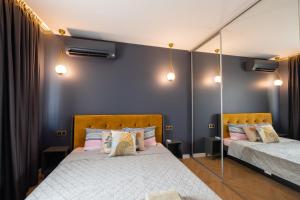 Duas camas num quarto com paredes azuis em TOPAZ Beachfront Apartment em Varna City