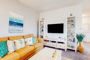 sala de estar con sofá y TV de pantalla plana en About the Waves, en Avon
