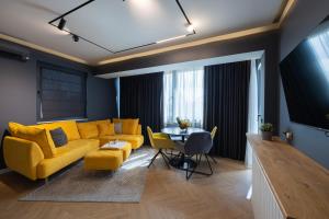 een woonkamer met een gele bank en een tafel bij TOPAZ Beachfront Apartment in Varna