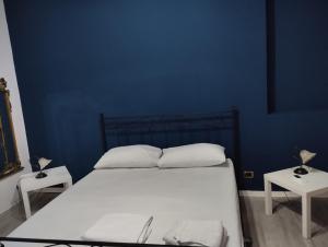 um quarto azul com uma cama e duas mesas em casa Giuseppe em Catânia