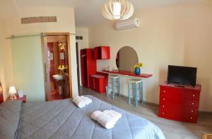 a bedroom with a bed and a tv and red cabinets at FURTURE'Rooms in Naples