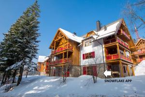 una casa grande en la nieve con un árbol en Bolfenk Snowflake app, en Hočko Pohorje