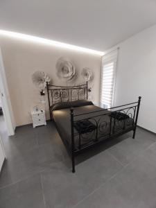 ein Schlafzimmer mit einem schwarzen Bett in einem weißen Zimmer in der Unterkunft Sirene452 - apartment - in Torvaianica