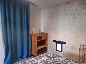 a bedroom with a bed and a blue curtain at Gîte VillaBoé in Villebois-Lavalette