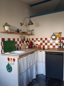 a kitchen with red and white checkered walls at Gîte VillaBoé in Villebois-Lavalette