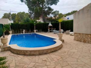a swimming pool in a yard with a patio at Villa Coco in Les tres Cales