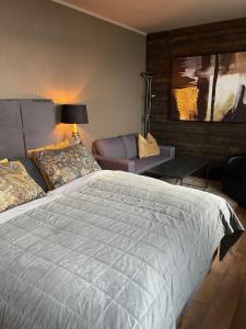 um quarto com uma cama grande e um sofá em Altafjord Gjestegaard em Alta