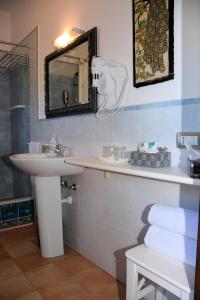 bagno con lavandino e specchio di Guest House La Carolina a Tigliole