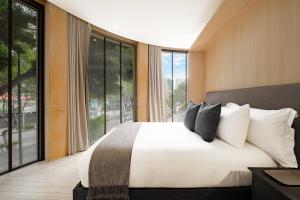 a bedroom with a large bed and large windows at ONTO Tonalá Mexico City in Mexico City