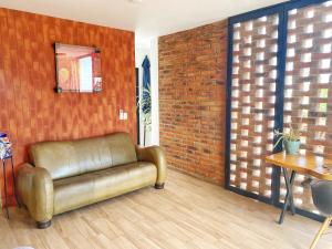 um sofá de couro num quarto com uma parede de tijolos em Exclusivo Loft en Santa Anita em Santa Anita