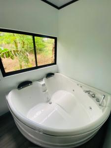 a white bath tub in a bathroom with a window at El Rincón del León in Quesada