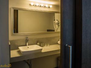 a bathroom with a sink and a mirror at Studio28 Boutique Rooms in Pärnu