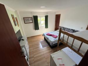 Un pequeño dormitorio con una cama y una escalera en Hotel Marquês de Maricá en Maricá
