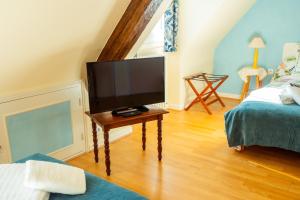 een woonkamer met een flatscreen-tv op een tafel bij RELAIS SAINT JACQUES in Amboise
