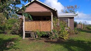una pequeña casa con una puerta de madera en un patio en Cabaña Uka Moana en Hanga Roa