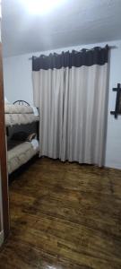 ein Wohnzimmer mit einem Vorhang und Holzboden in der Unterkunft hostel ARCO in Cusco