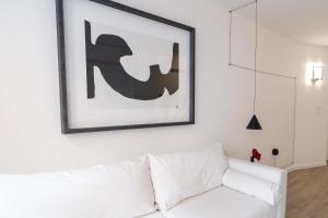 a white couch in a living room with a picture on the wall at Apartamento de lujo en el centro de Murcia By Alquileres ElConserje in Murcia