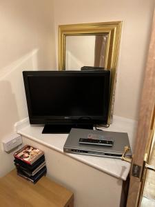 a flat screen tv sitting on a shelf with a laptop at The Gallery in Middlesbrough
