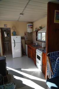 a kitchen with a white refrigerator and a stove at Casa container a 15km de Madryn in Puerto Madryn