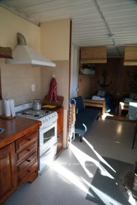 a kitchen with a stove and a living room at Casa container a 15km de Madryn in Puerto Madryn