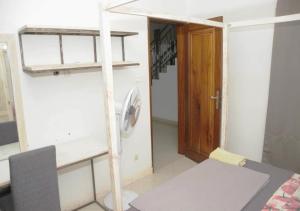 a room with a bed and a wooden door at Chez Ouly in Dakar