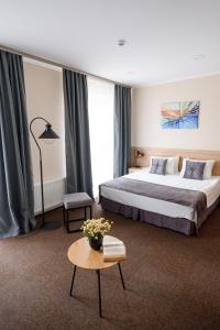 um quarto de hotel com uma cama e uma mesa em Nota Bene Loft em Lviv
