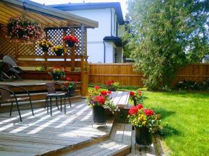 un patio con mesa, sillas y flores en U of A Homestay, Trails & Whyte Ave, en Edmonton