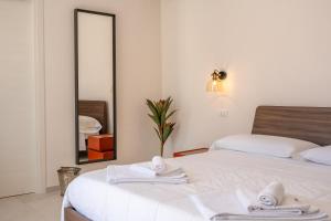 a bedroom with two beds and a mirror at Murieri Rooms in Otranto