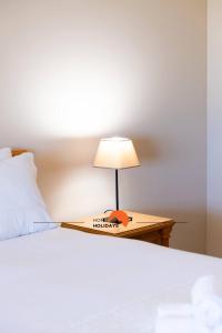 a bed with a table with a lamp on it at #130 Praia Village by Home Holidays in Vilamoura +48 photos