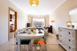a dining room with a white table and chairs at #130 Praia Village by Home Holidays in Vilamoura