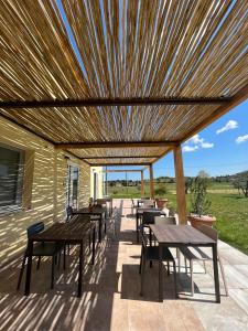 a wooden pergola with tables and chairs on a patio at Agrestia azienda agricola in Bertinoro