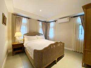 1 dormitorio con 1 cama y 1 mesa con lámpara en The Eyrie O1 Khao Yai, en Ban Bung Toei