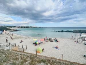 un groupe de personnes sur une plage avec des parasols dans l'établissement Casa Amore, à Tarente