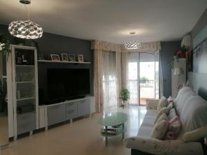 a living room with a couch and a tv at Habitaciones Torremolinos in Torremolinos
