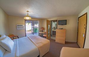 Marble CanyonにあるMarble Canyon Lodgeの大型ベッドとテレビが備わるホテルルームです。