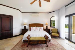 Schlafzimmer mit einem Bett, einem Stuhl und Fenstern in der Unterkunft Casa La Cima in Playa Hermosa