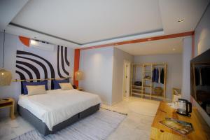 ein Schlafzimmer mit einem großen Bett und einem TV in der Unterkunft Cowork Lab Suites in Maputo