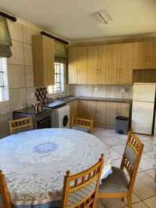 a kitchen with a table and some chairs and a refrigerator at Hekpoort Rorymi Guest farm in Hekpoort