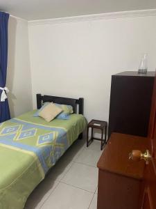 a bedroom with a bed and a dresser in it at Linda habitación buena ubicación in Bogotá