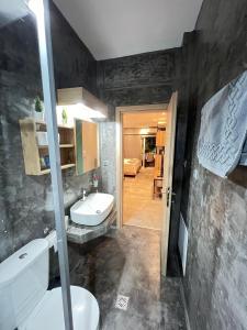 a bathroom with a sink and a toilet in a room at Modern apartment in the heart of the city in Alexandroupoli