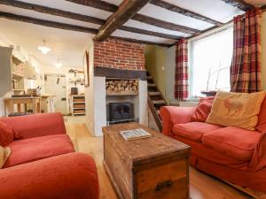 a living room with two red couches and a fireplace at Driftwood Cottage in Harwich