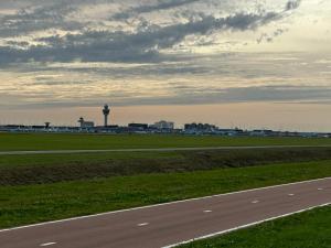 an airport runway with a control tower in the distance at Bnb de leeuw in Badhoevedorp