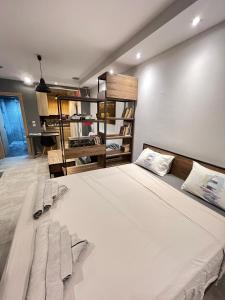 um quarto com uma grande cama branca com almofadas em Modern apartment in the heart of the city em Alexandroúpolis