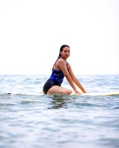 een vrouw op een surfplank in het water bij DesArt in Tamraght Ouzdar