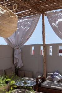 eine Terrasse mit einer Couch und einem Tisch in der Unterkunft DesArt in Tamraght Ouzdar